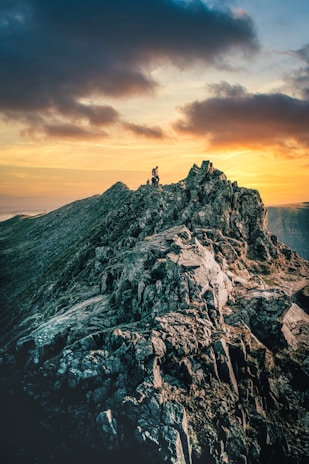 A rugged mountain landscape under a dramatic sunset.