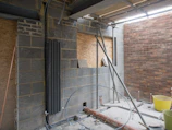 white metal pipe on brown brick wall