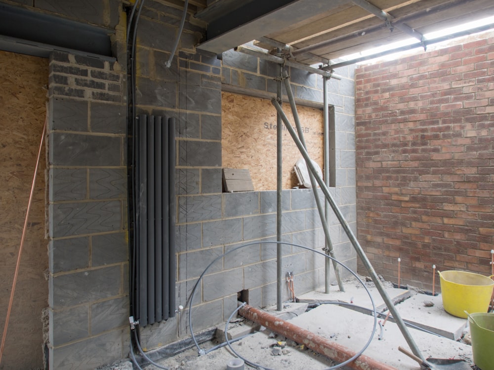 white metal pipe on brown brick wall