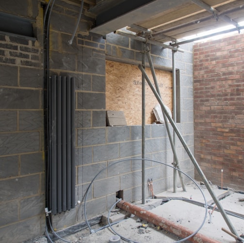 white metal pipe on brown brick wall