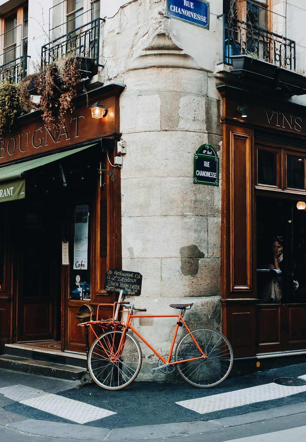 red city bike parked beside brown wooden framed glass window