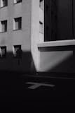 Black and white photograph of an urban street scene with artistic shadows