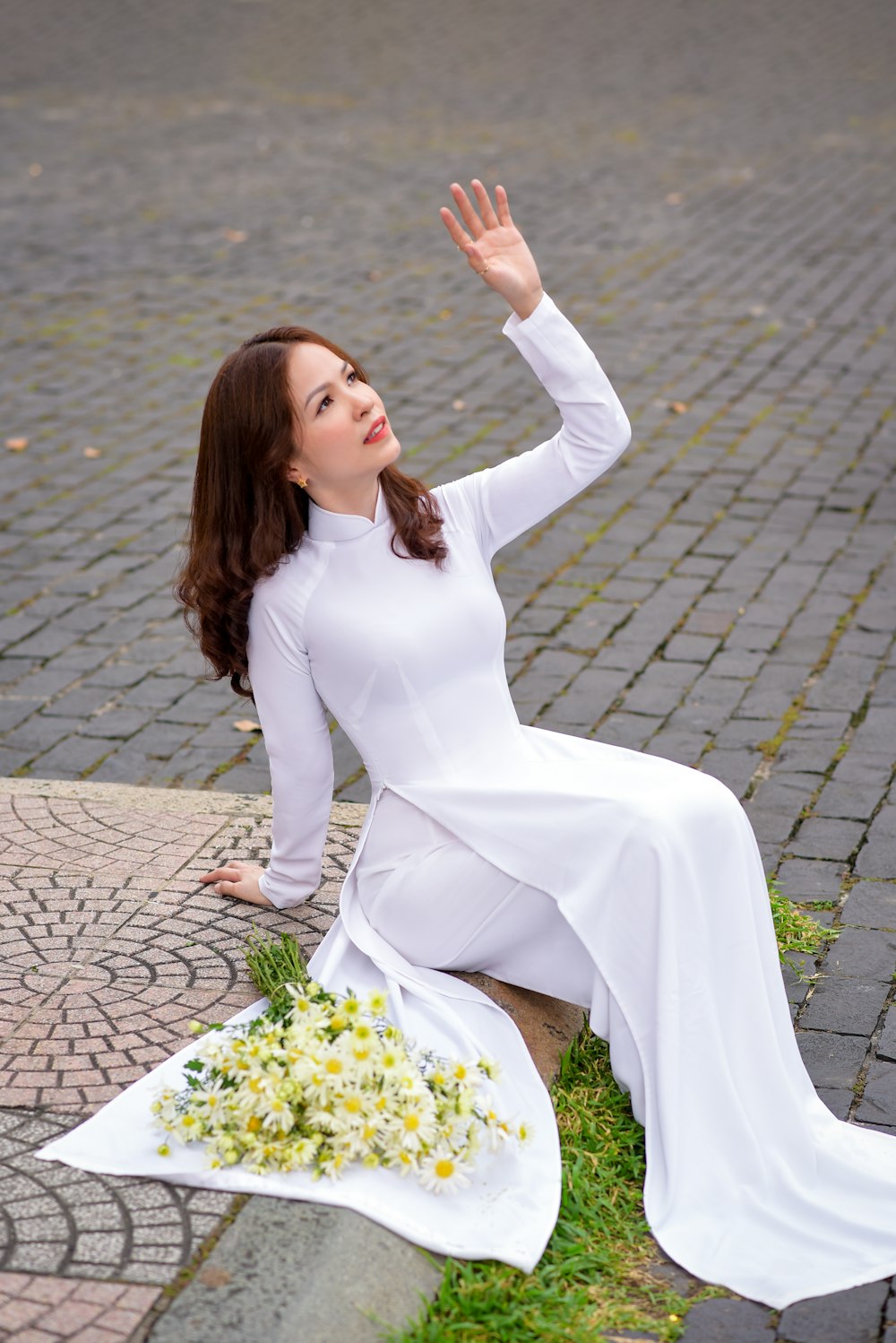 donna in abito bianco a maniche lunghe in piedi sul pavimento di mattoni