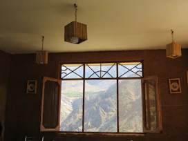 Sunlit bedroom in the Superior Mountain View Apartment with windows framing the rugged landscape.