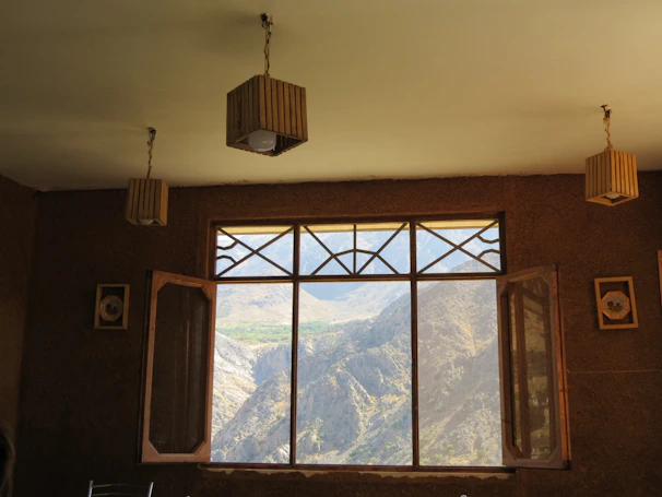 Sunlit bedroom in the Superior Mountain View Apartment with windows framing the rugged landscape.