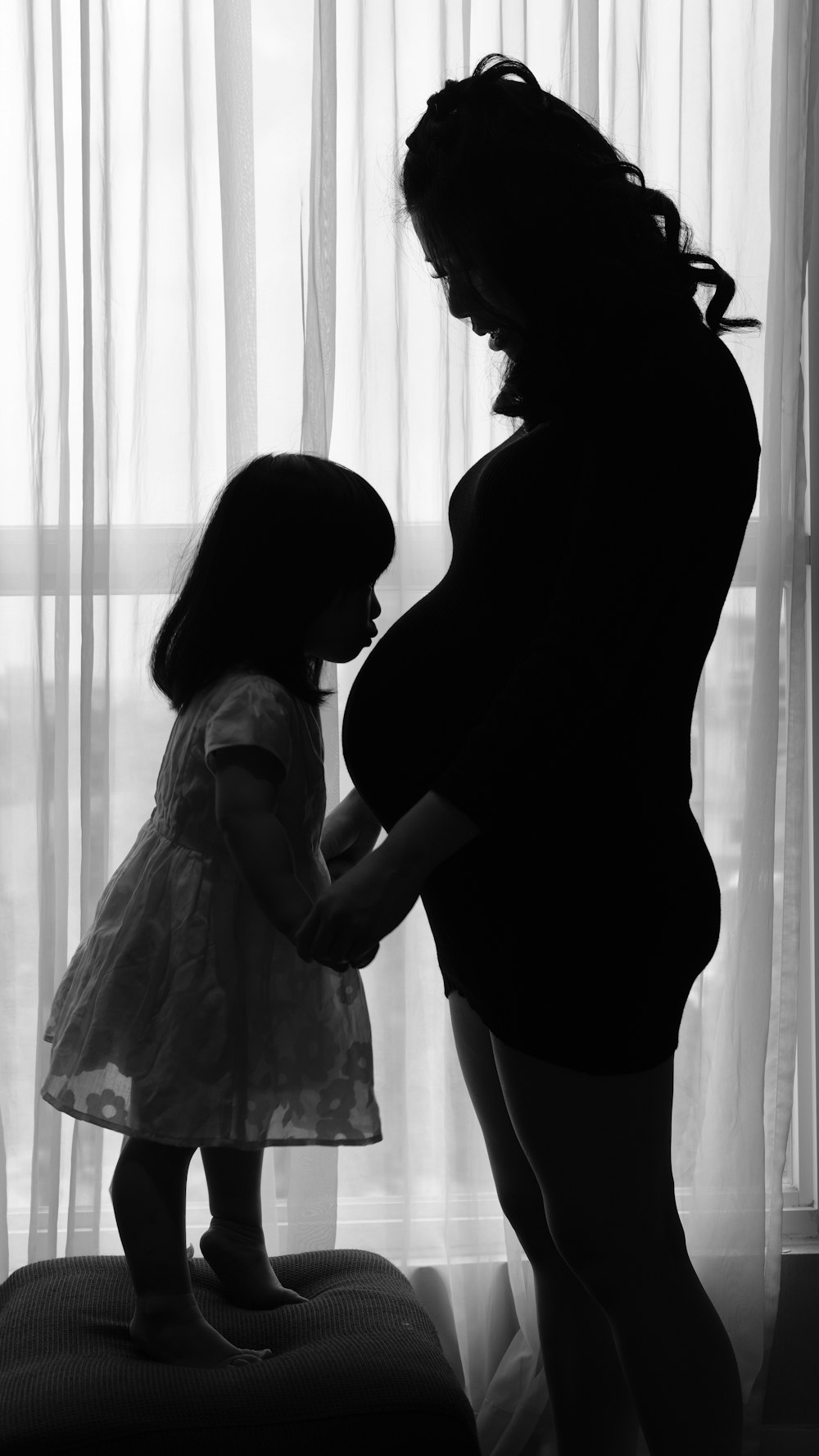 Mujer en vestido blanco de pie junto a mujer en vestido negro