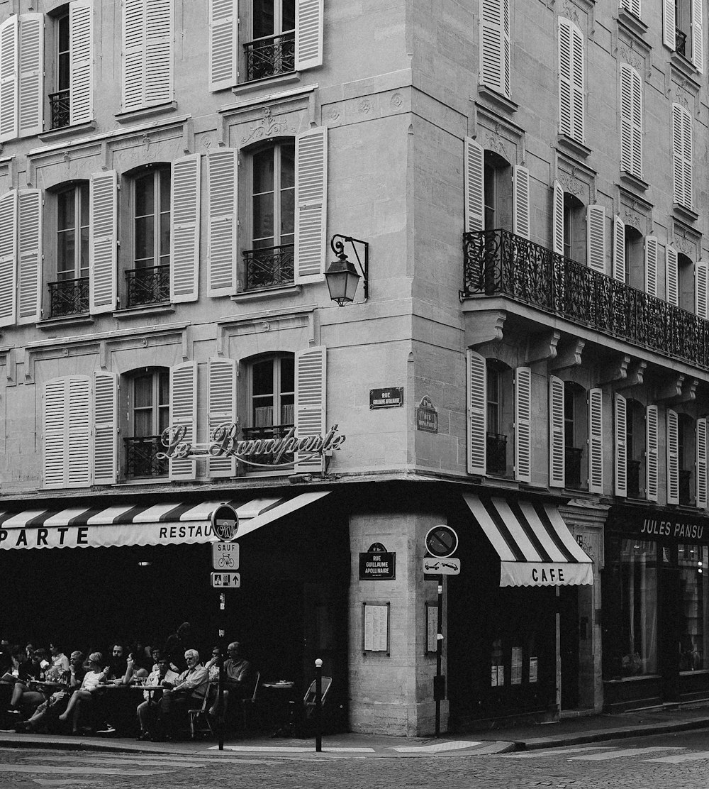 grayscale photo of people in front of building