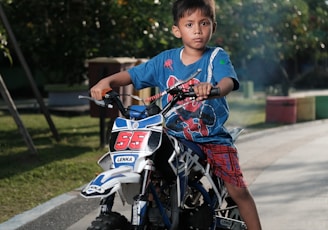 boy in blue t-shirt riding on motorcycle