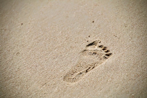 Carbon foot prints on white sand