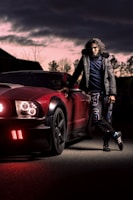 woman in black jacket and black pants standing beside red car