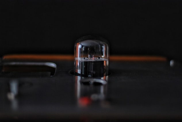 Close-up of a sleek electron beam evaporation source glowing softly inside a vacuum chamber.