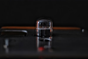 A close-up view of a vacuum tube on a dark surface with a soft focus background, creating a sleek and industrial aesthetic.