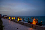 Chic restaurant terrace overlooking ocean with ambient evening lights.