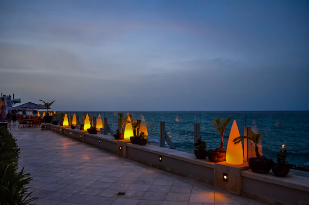 A serene seaside terrace at sunset with soft gold accents and navy blue skies reflecting on the water.