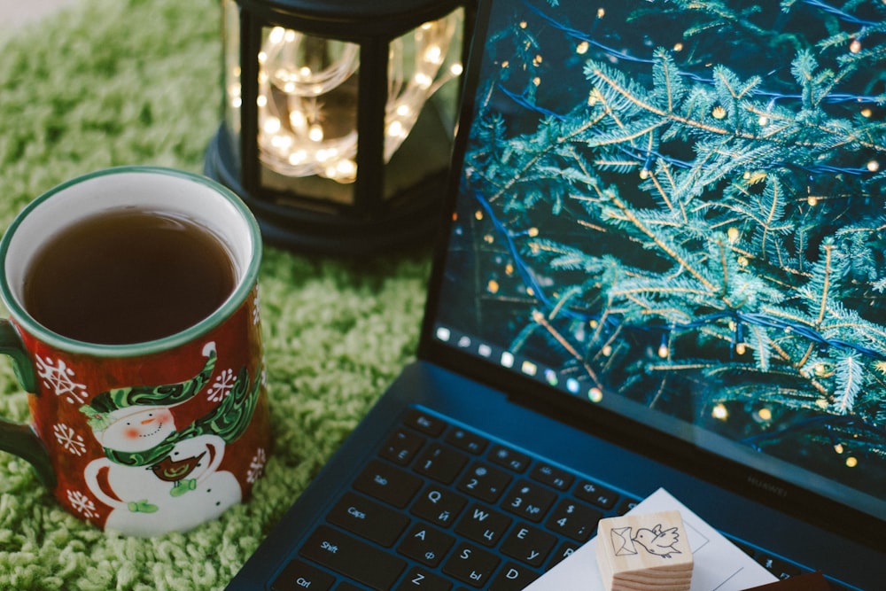 red and white ceramic mug on black laptop computer