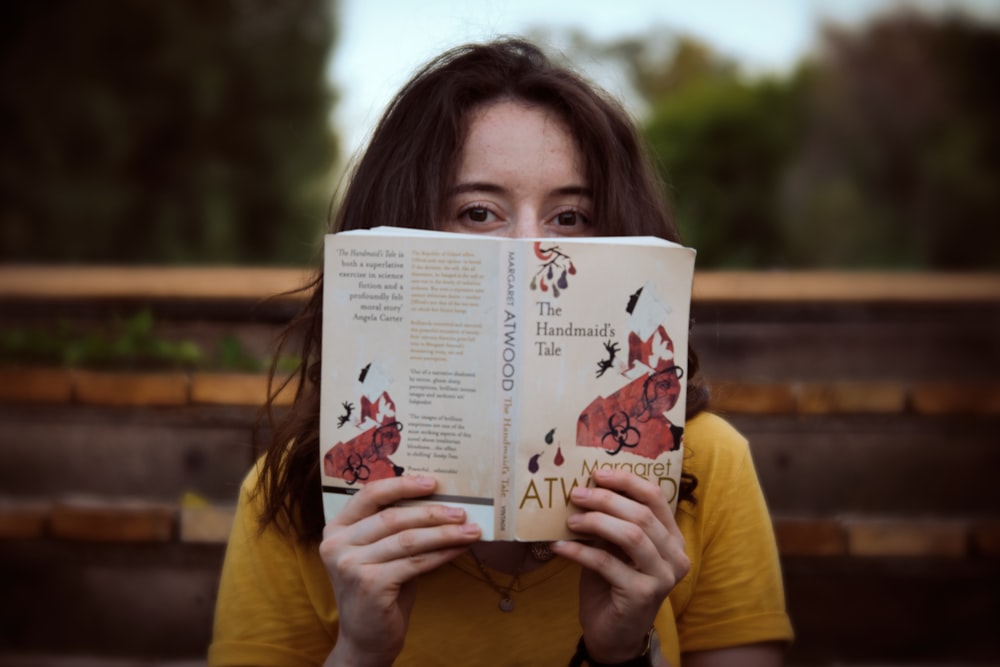 woman in yellow shirt holding white paper