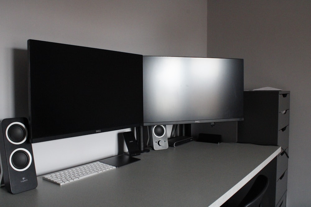 black flat screen computer monitor on white wooden desk