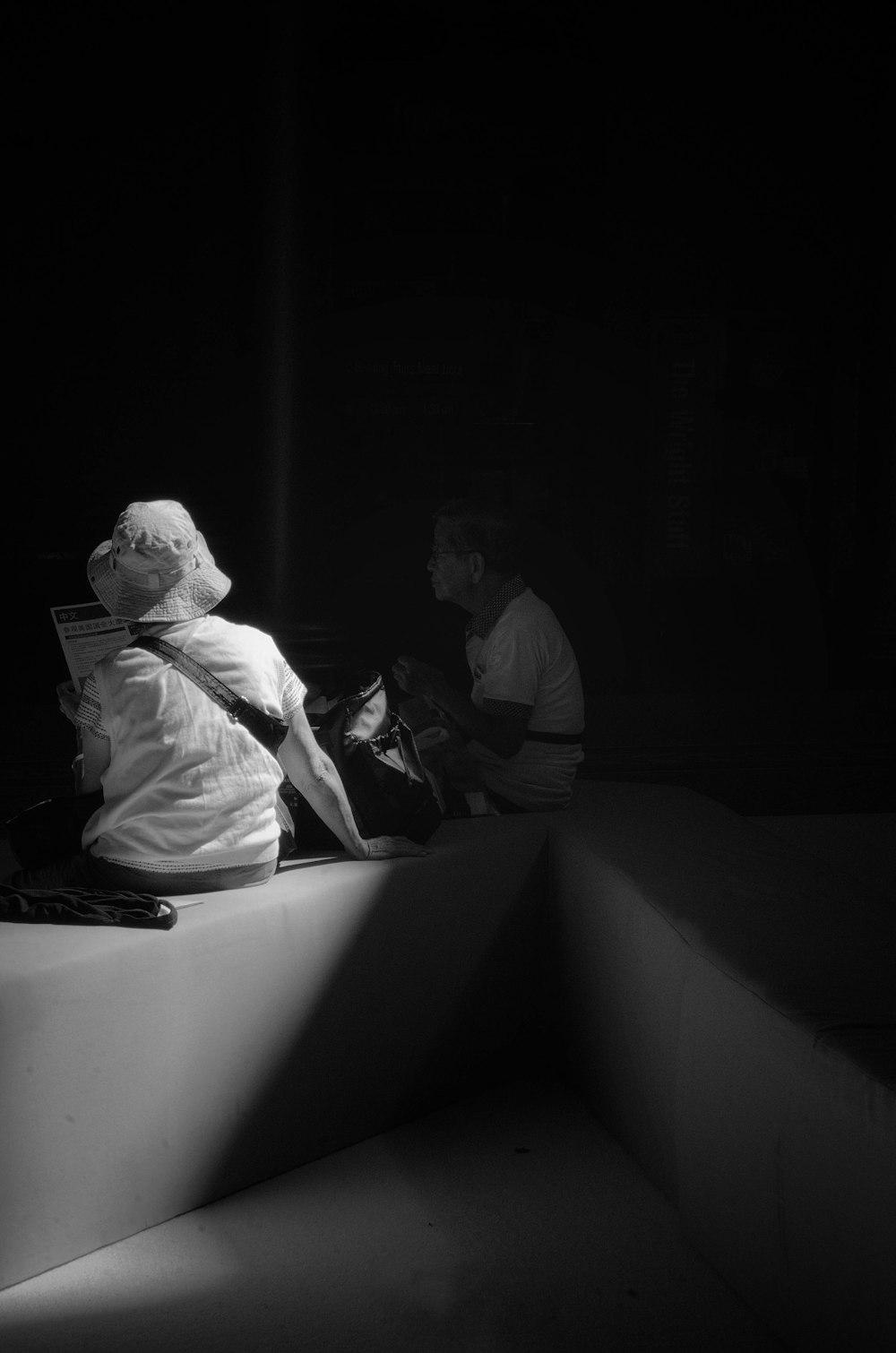 man in white dress shirt sitting on white concrete bench