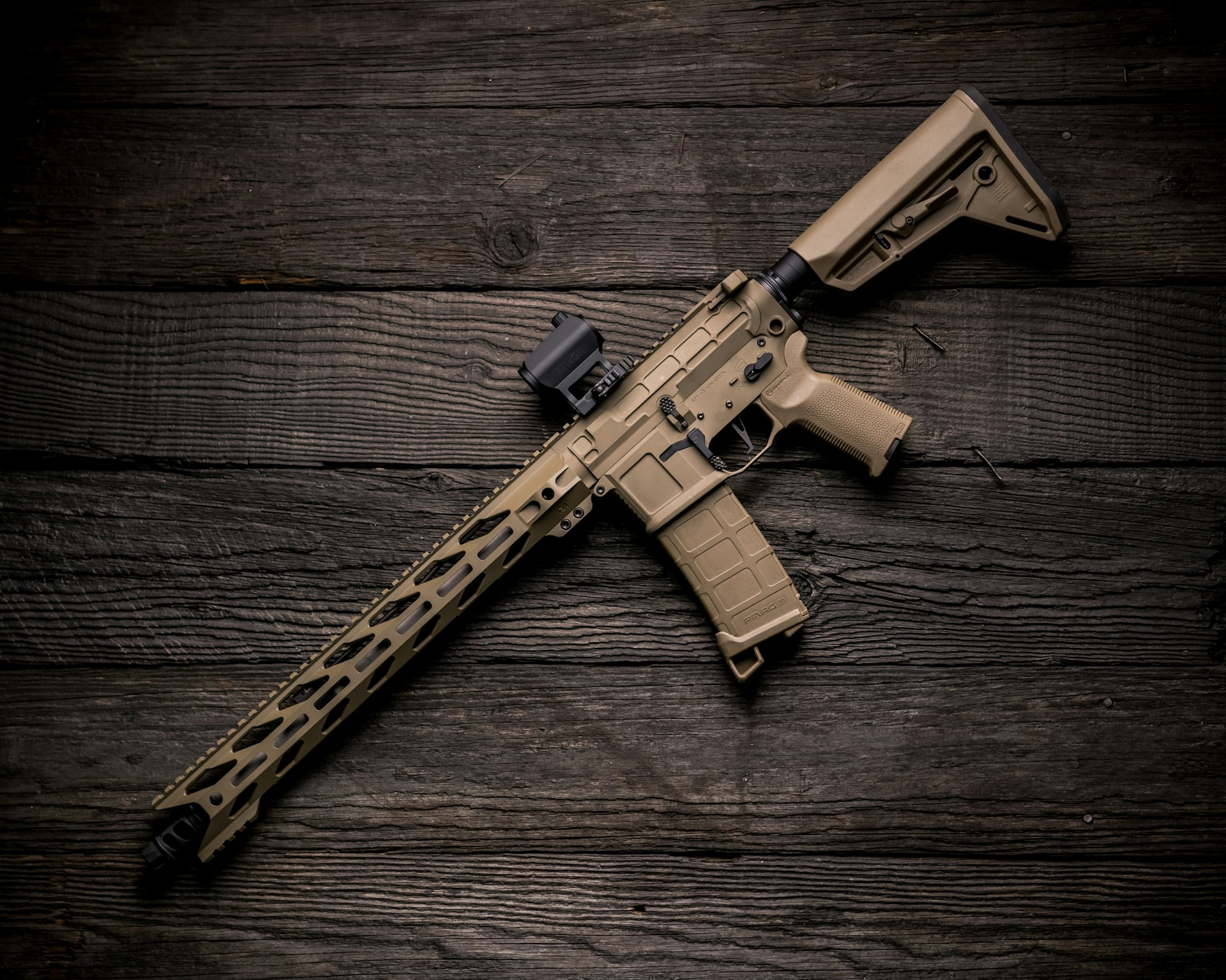 black and brown rifle on brown wooden surface