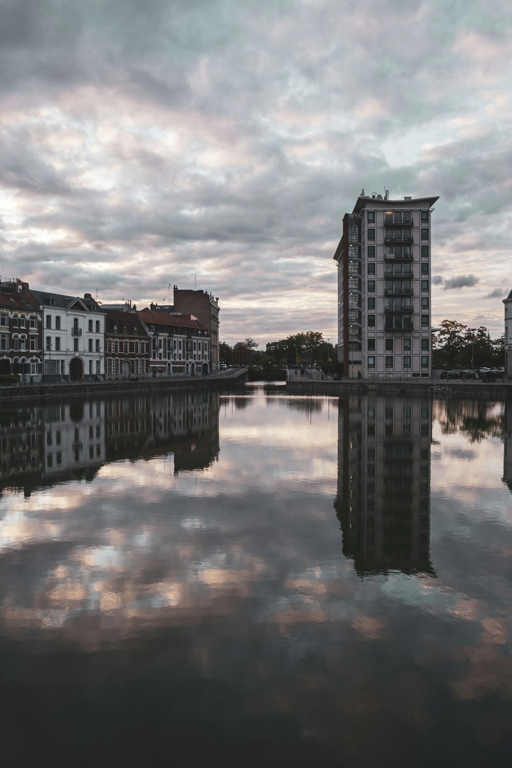 body of water near buildings under cloudy sky during daytime