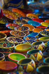 Colorful ceramic bowls stacked gently, showcasing vibrant glazes and rustic textures.
