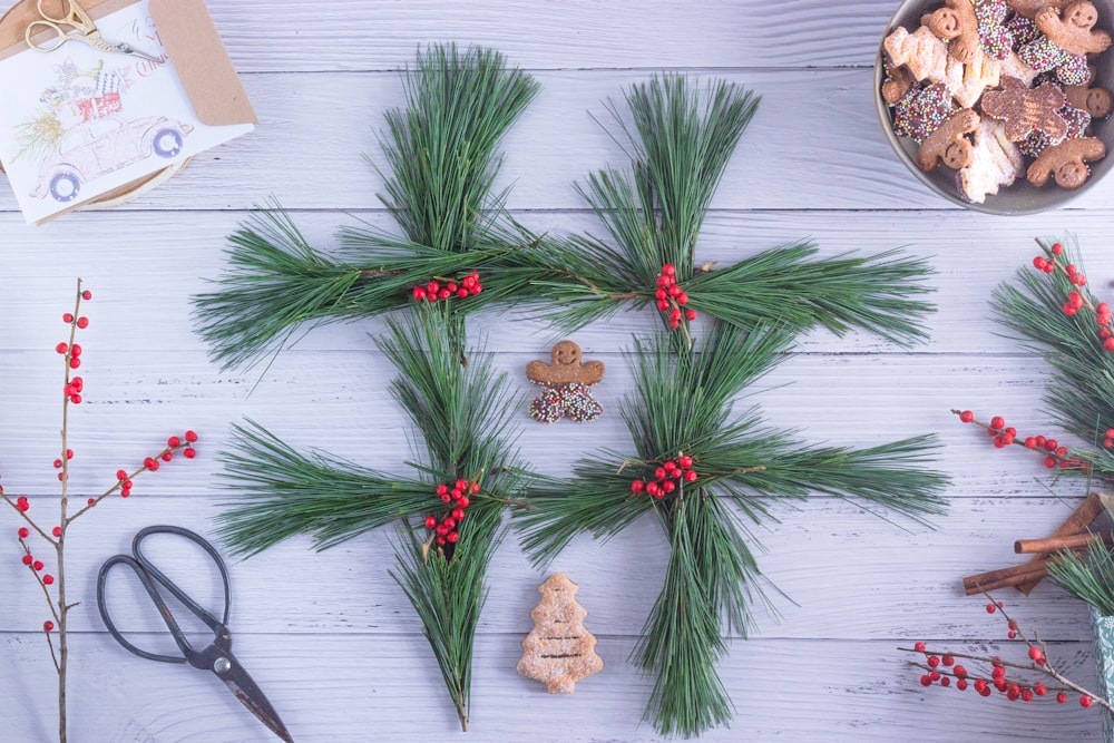 green and red pine cone on white wooden table