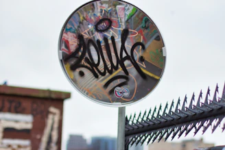 A convex mirror mounted on a corner of a warehouse, reflecting the surrounding industrial area.