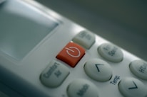 Close-up of a modern AC remote control set against a clean wall background.