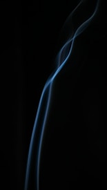 Wavy, translucent strands of blue light contrast against a dark background, creating an abstract visual effect.