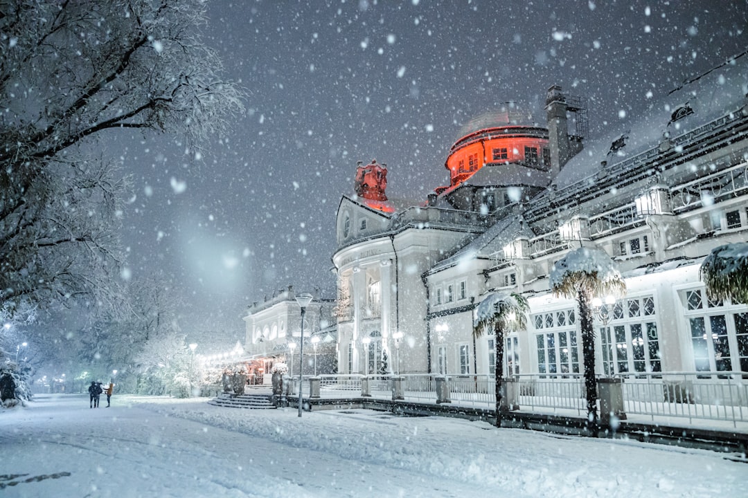 white and red concrete building during snow,