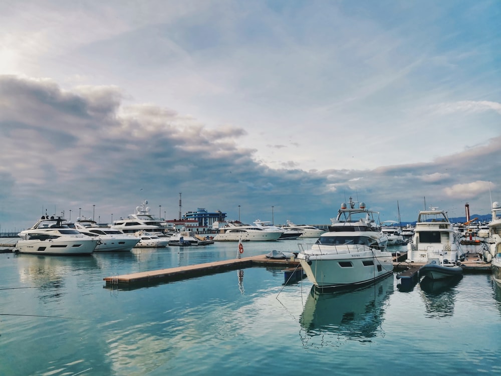 white boats on sea under white clouds during daytime