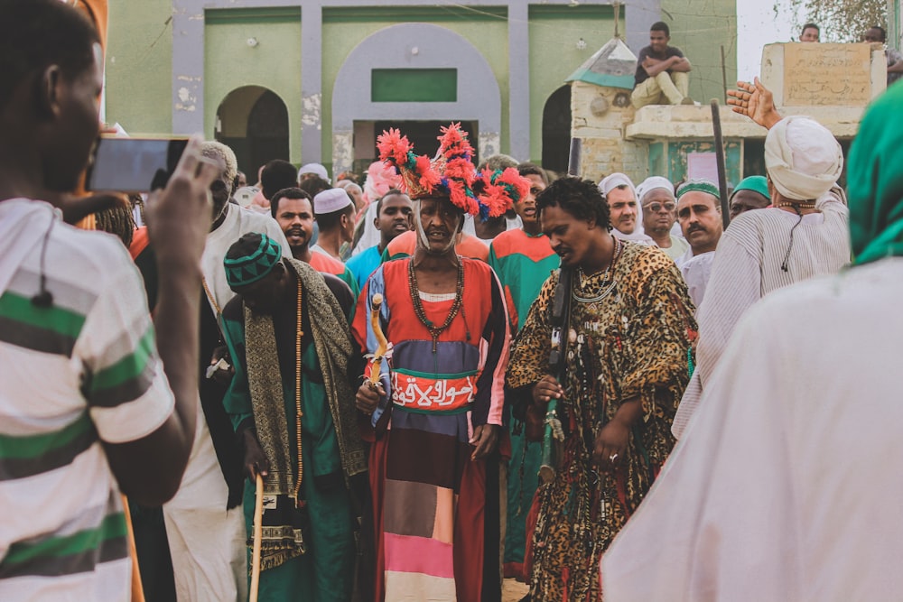 personnes en costume traditionnel debout dans la rue pendant la journée