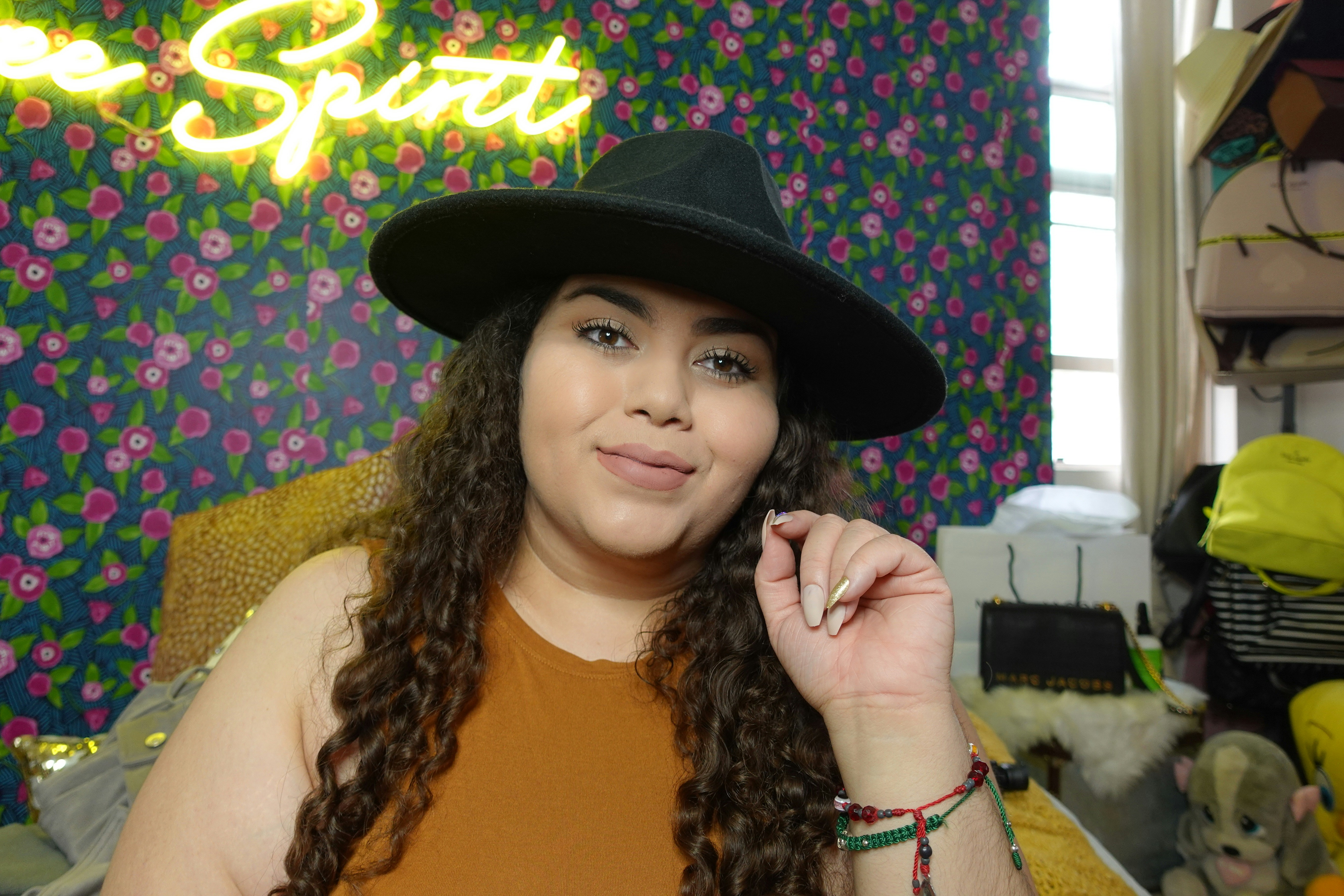 Una mujer emprendedora de origen latino trabajando con concentración en su taller, rodeada de herramientas y materiales, simbolizando la innovación y la creatividad.