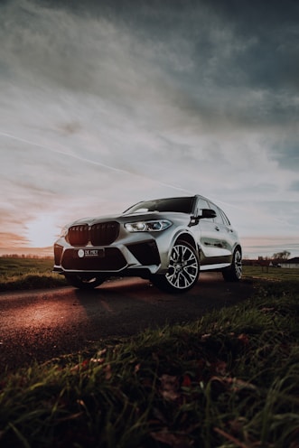 white bmw m 3 coupe on brown field under gray cloudy sky during daytime