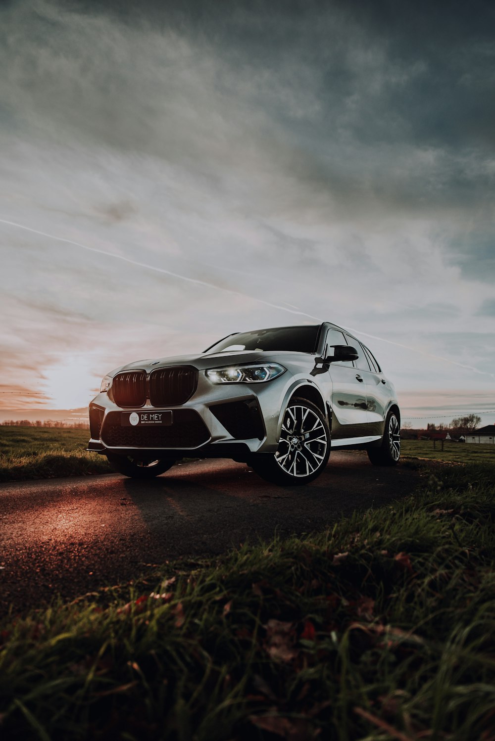 white bmw m 3 coupe on brown field under gray cloudy sky during daytime