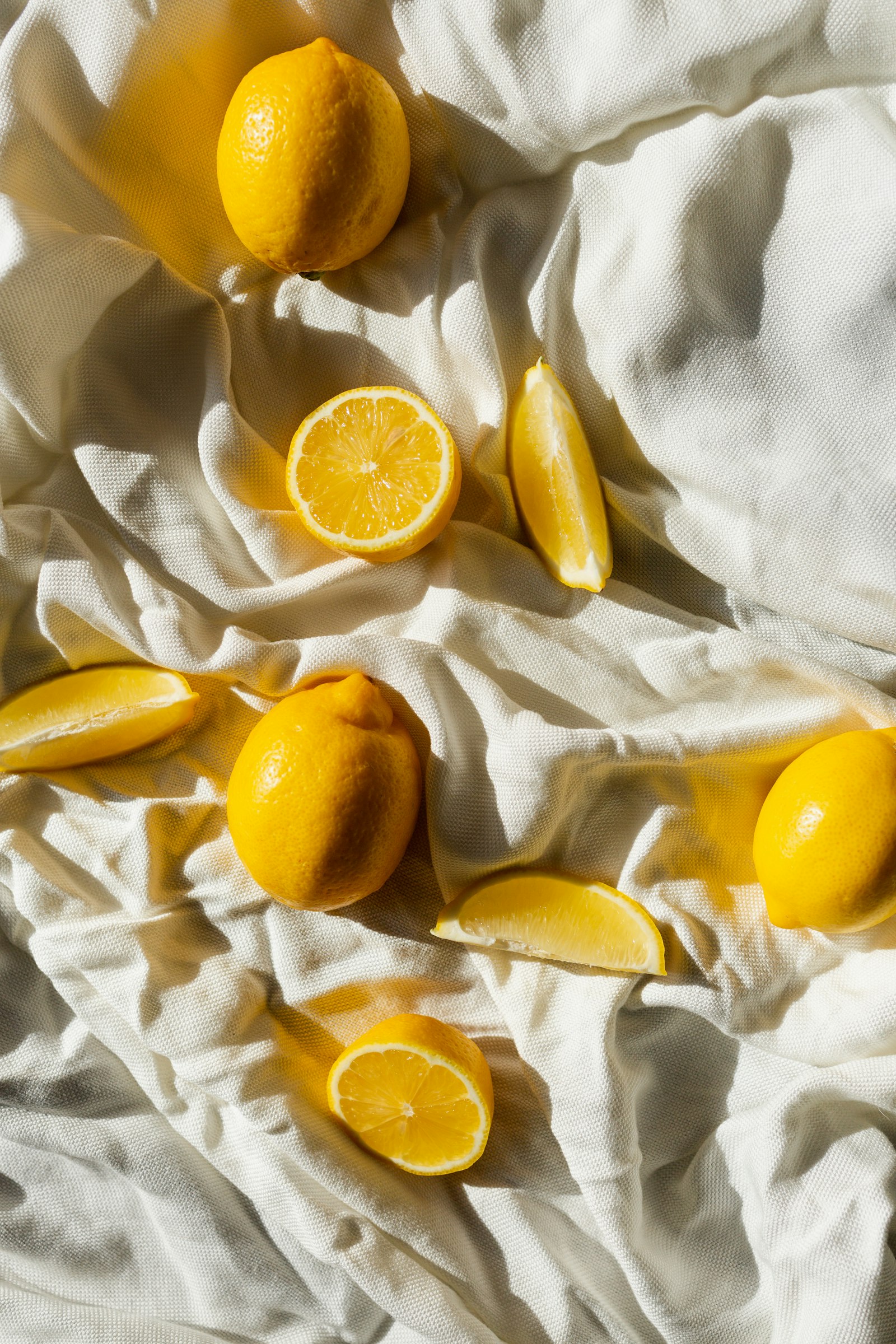 Des citrons entiers et coupés sur un tissu clair