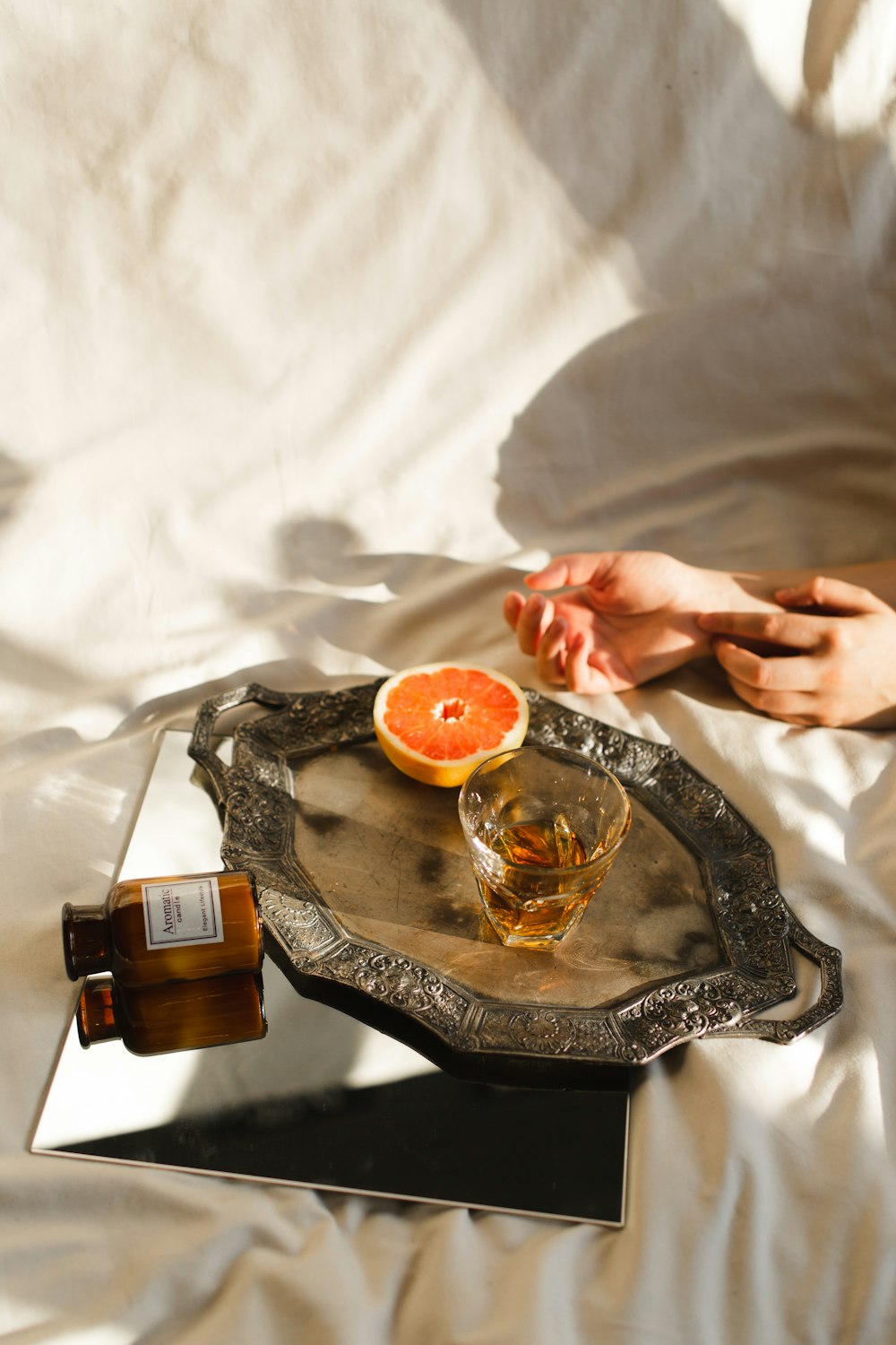 person holding clear glass cup with orange liquid