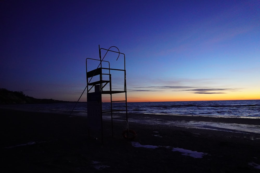 silhouette of person standing on beach during sunset