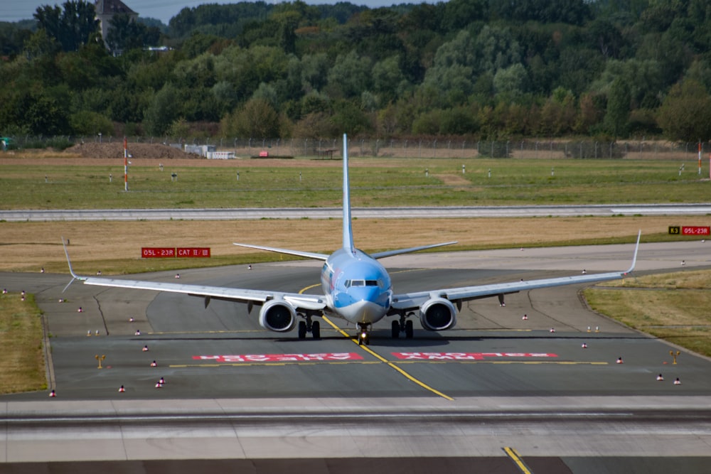 aeroplano bianco e blu sull'aeroporto durante il giorno