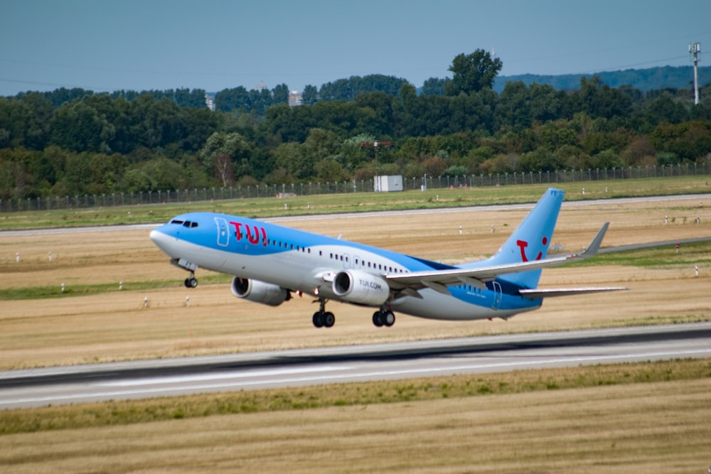 Avión de pasajeros blanco y azul en el aeropuerto durante el día