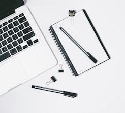 Minimalist workspace with a laptop showing brand strategy sketches.