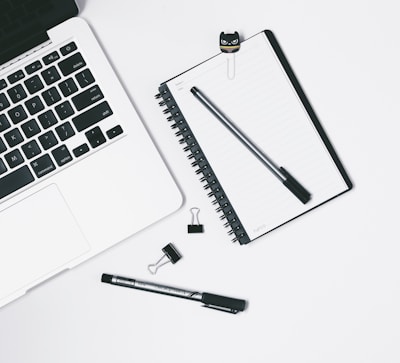 Minimalist workspace with a notebook, pen, and credit card on the desk.