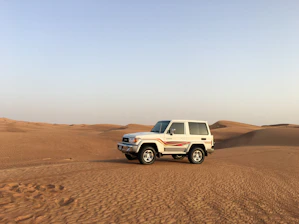 A red tow truck swiftly rescuing a stranded car on a desert highway