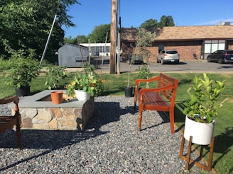 Concrete garden benches and planters arranged in a sunny backyard.