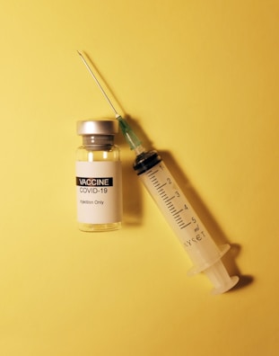 An image showing a vaccine vial with a syringe.