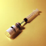 A close-up of a vaccination vial labeled with the clinic’s branding, resting on a sterile tray.