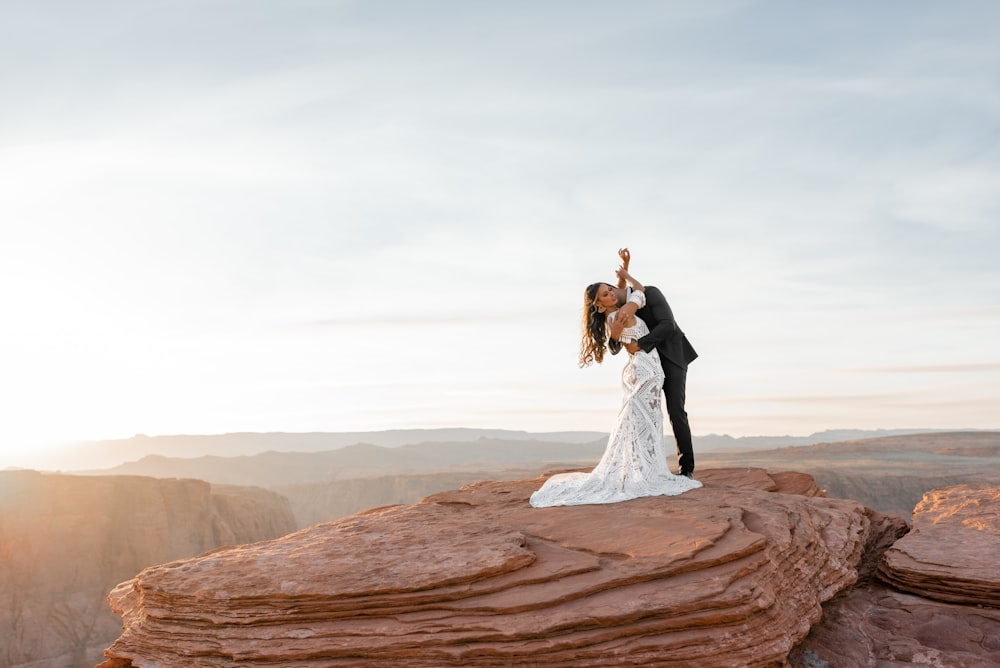homem e mulher se beijando na formação rochosa marrom durante o dia