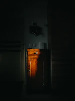 A freshly painted dark cabinet glowing under warm workshop lights.