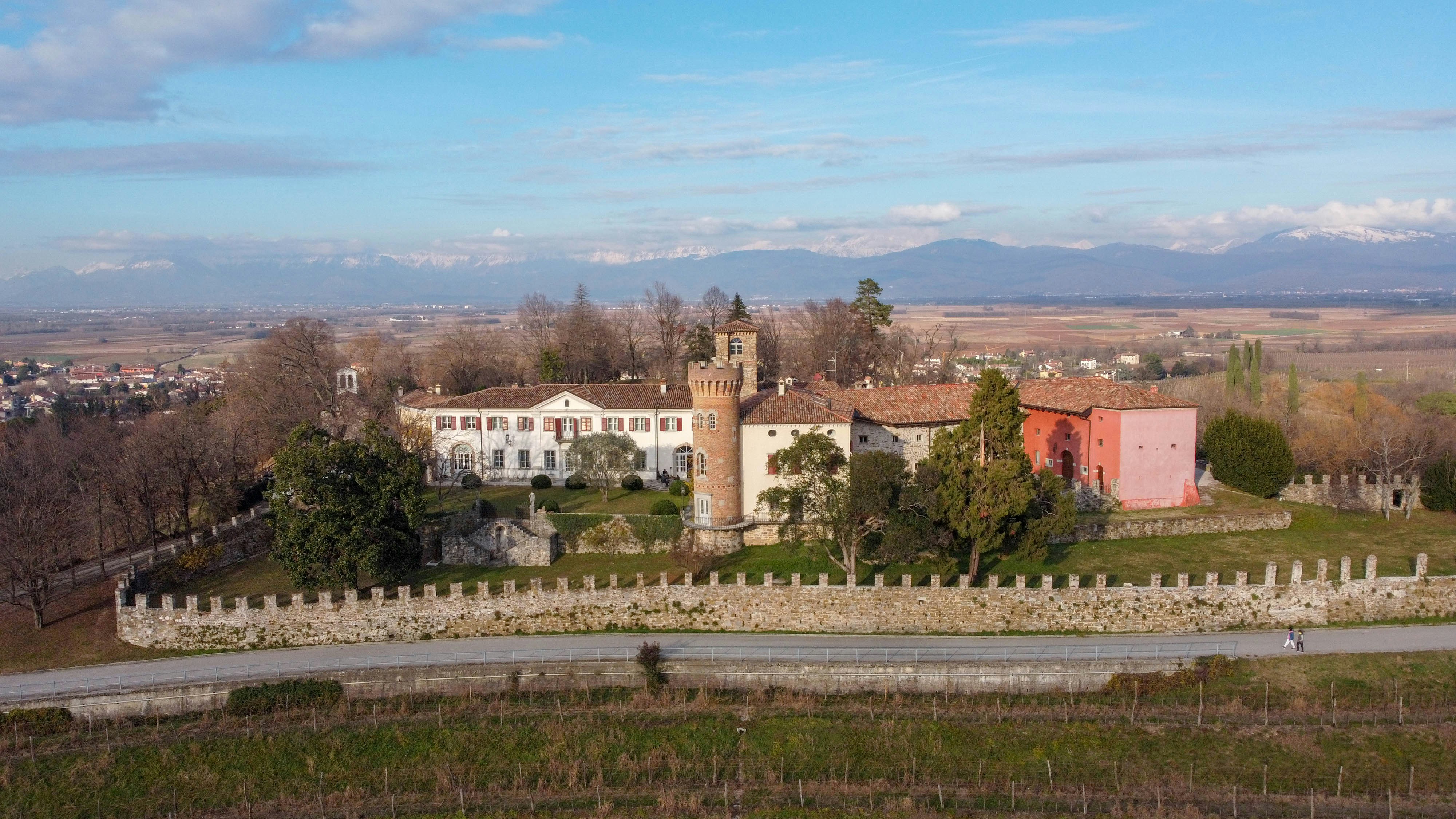 brown and white concrete building near green trees under blue sky during daytime