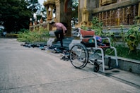 woman in pink long sleeve shirt and blue denim jeans sitting on black wheelchair